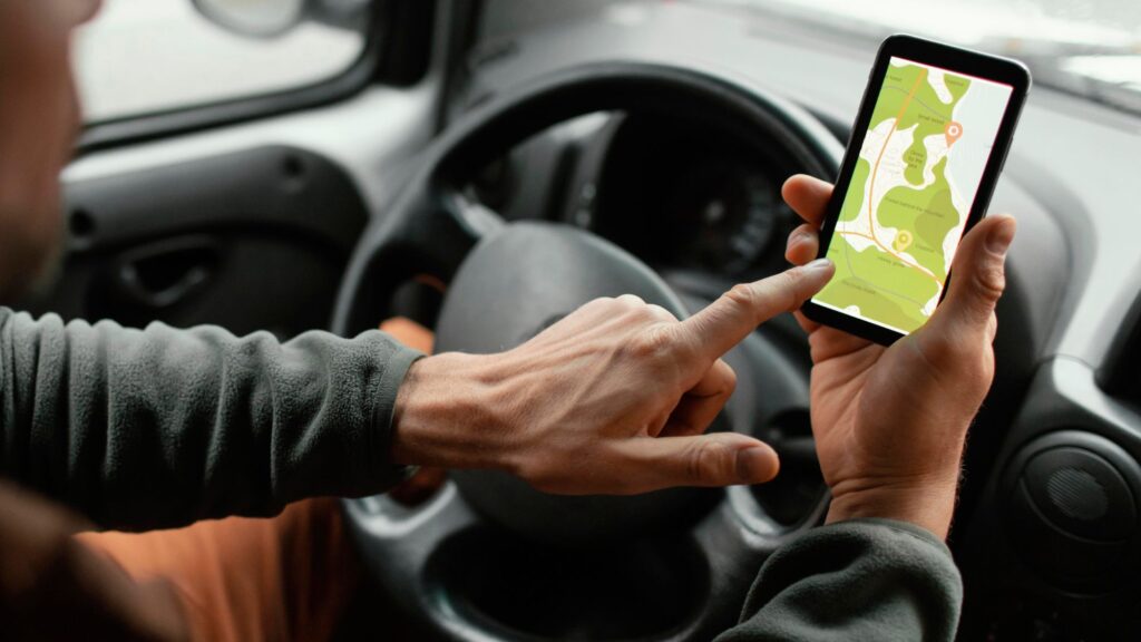 A man showcasing on his phone how vehicle tracking systems enhance driver safety