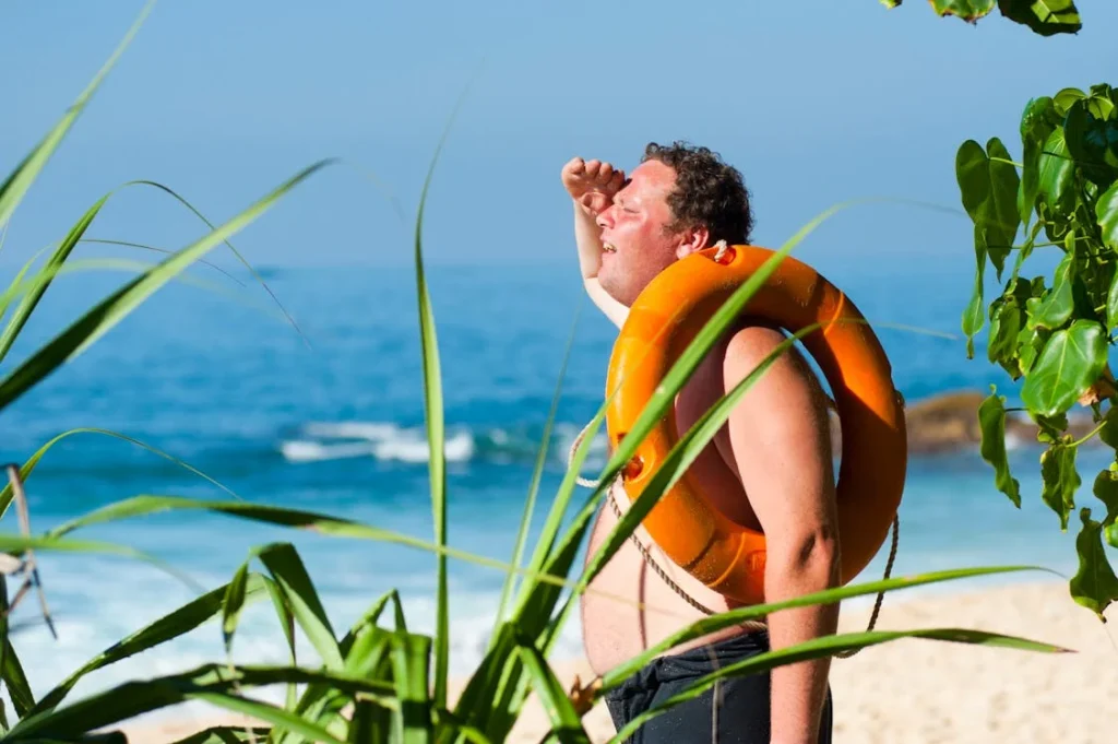 A person on beach trying to see not visible object under the sun